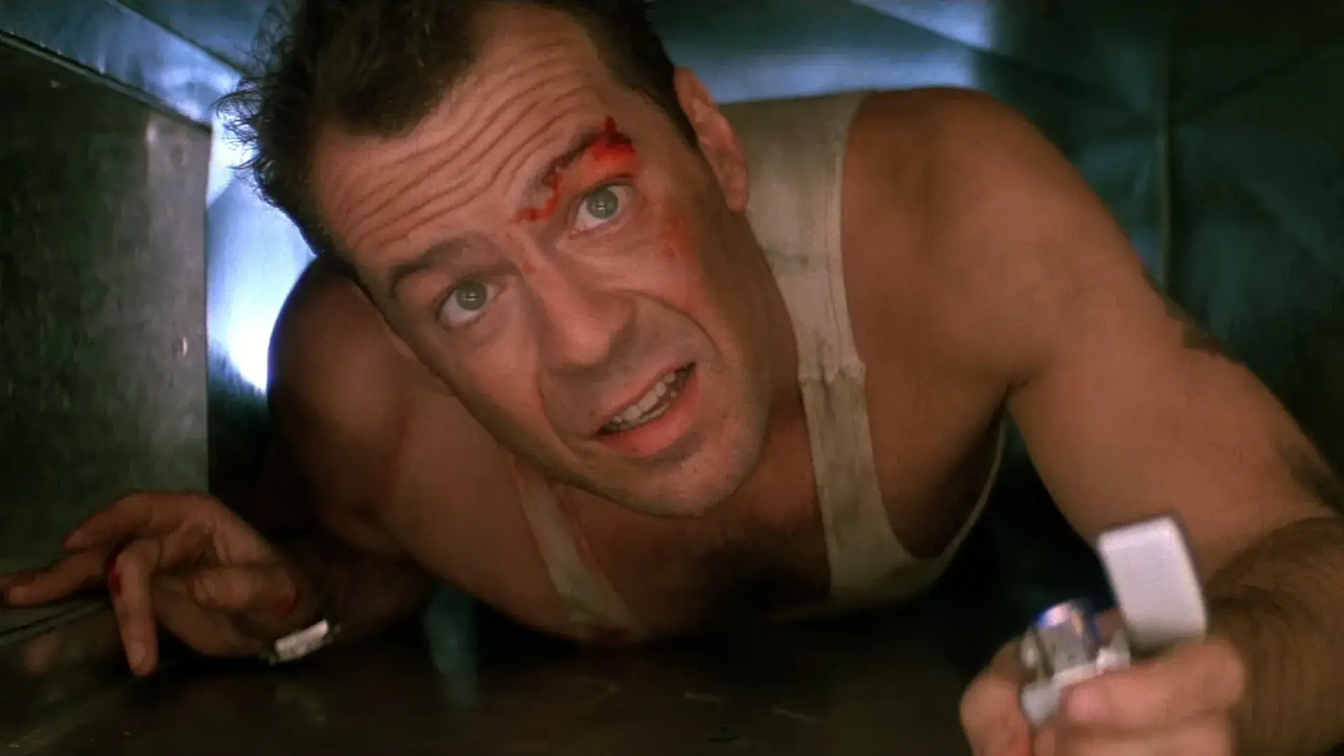 Bruce Willis en su papel de John McClane en Jungla de cristal, título original Die Hard, en uno de los conductos de ventilación