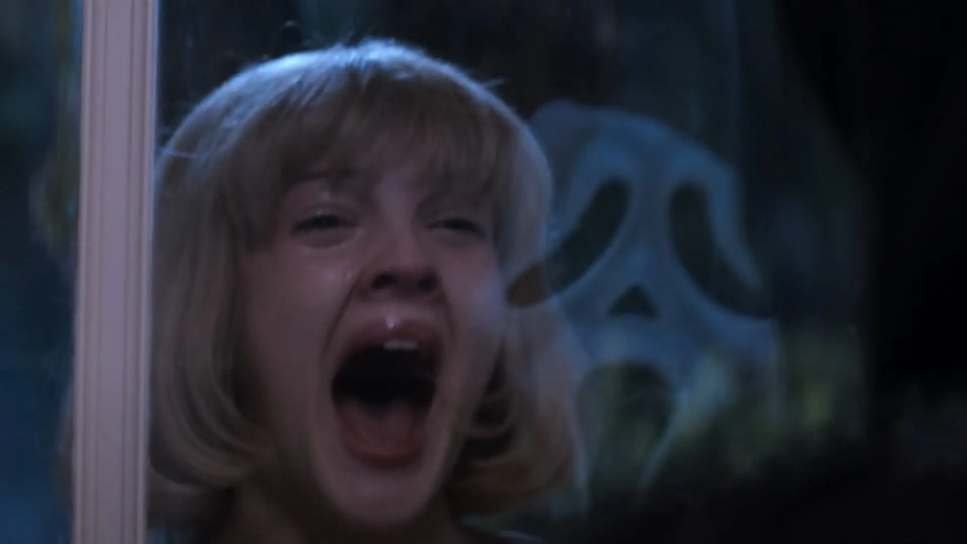 Fotograma de Scream con una mujer gritando asustada al ver una mascara blanca que grita