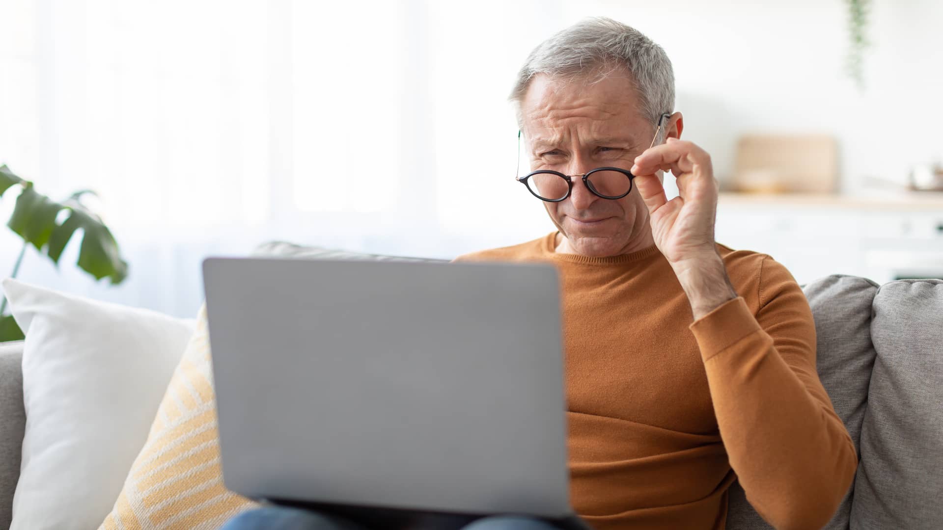 hombre mayor con su ordenador que va a dar de baja su suscripcion con la plataforma netflix