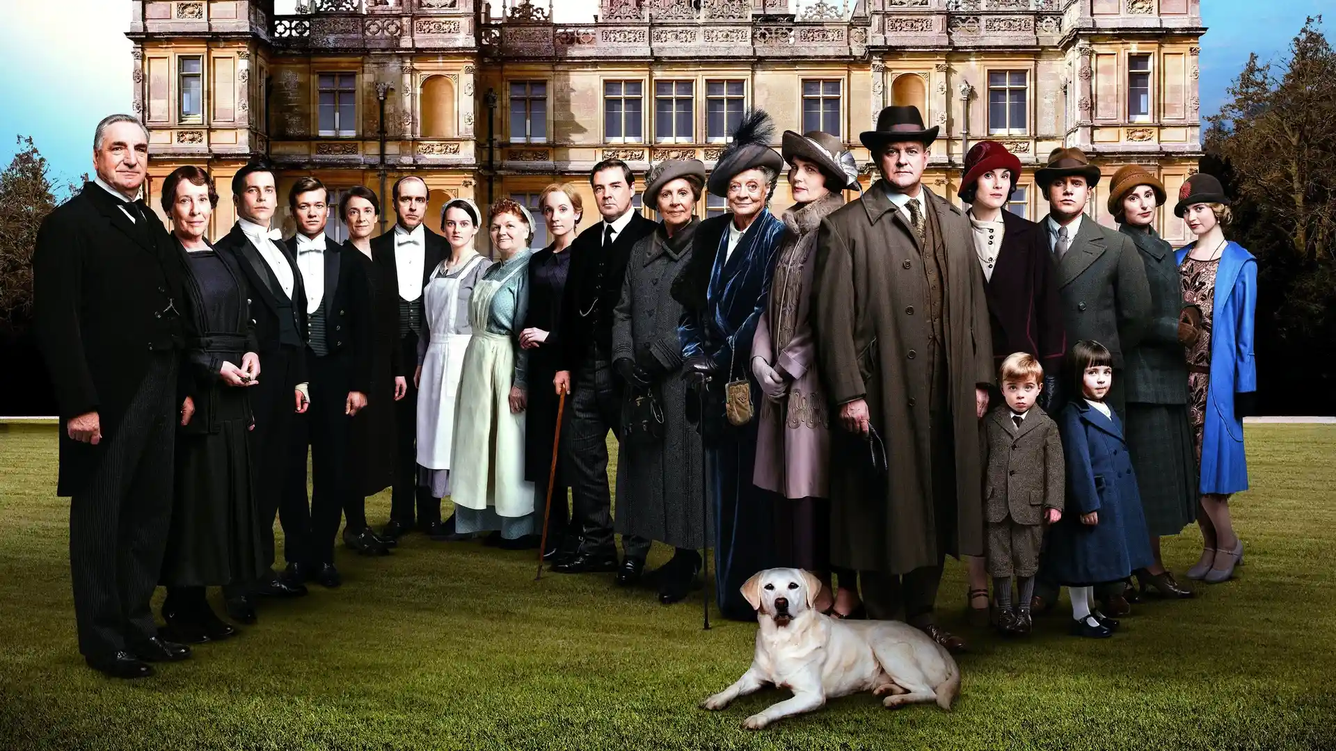 Personajes de la serie Downton Abbey colocados en fila frente a un castillo 