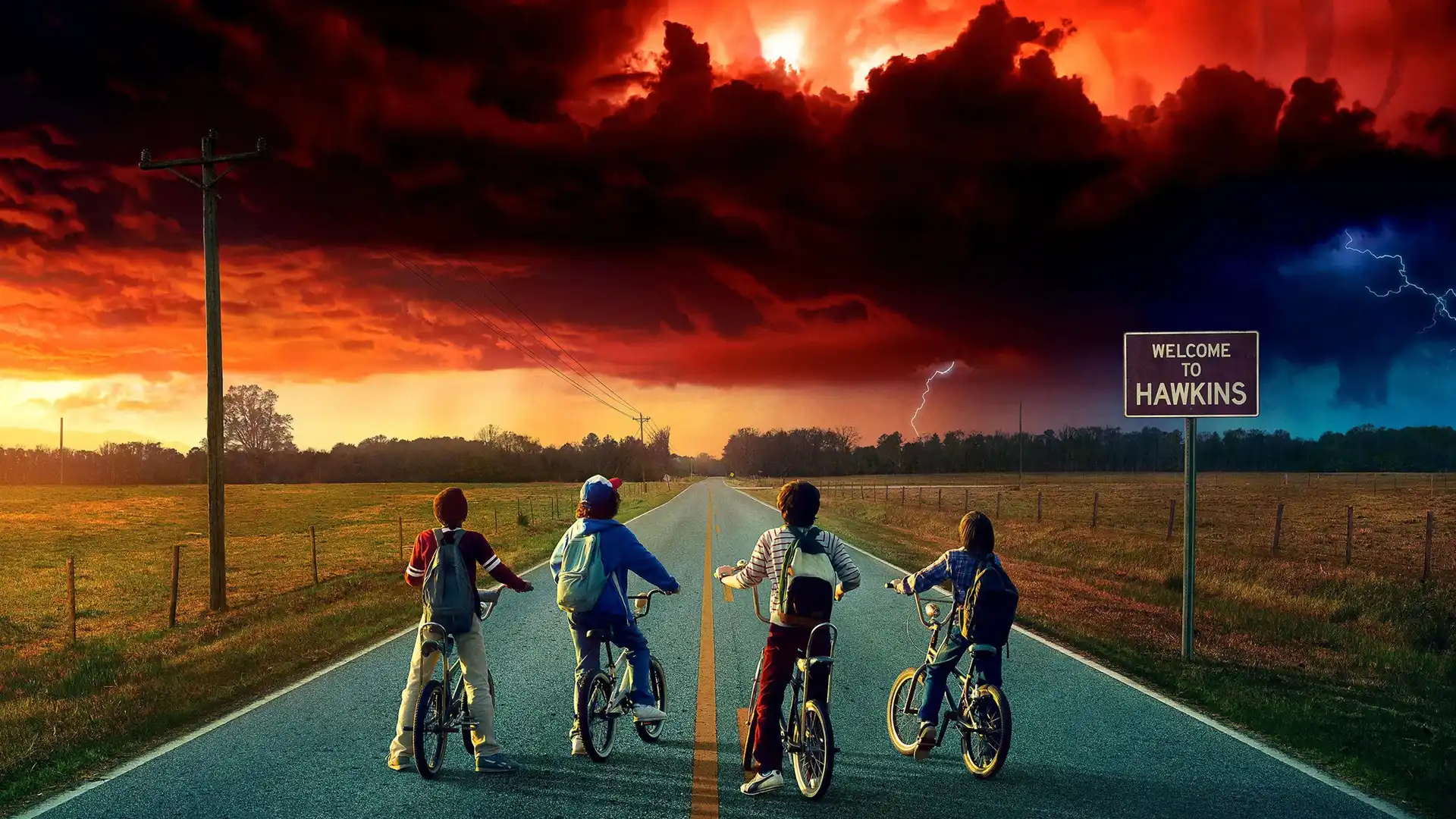 Imagen promocional de la serie stranger things en la que se ve a los cuatro amigos en sus bicis mirando hacia un horizonte perturbador